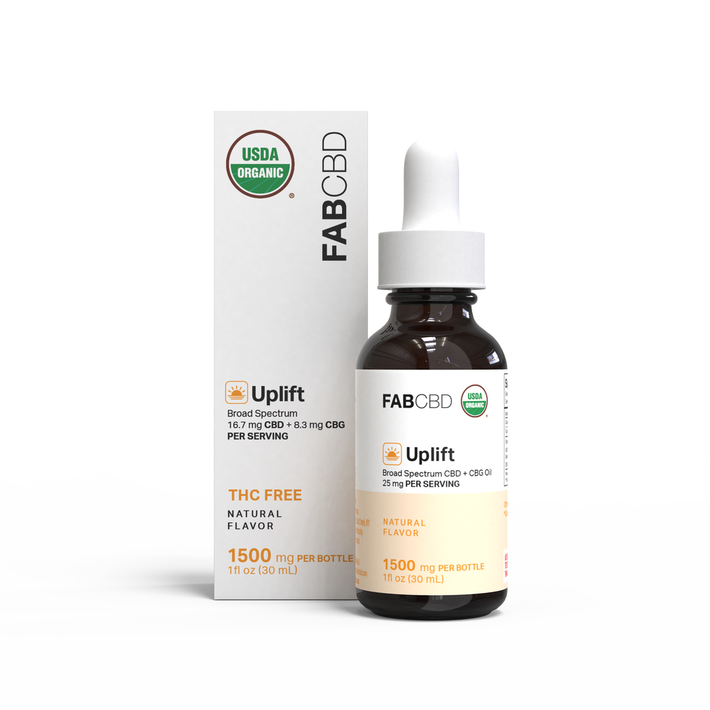 FAB CBD 'Uplift' broad spectrum CBD + CBG oil, showing a white box with a green USDA Organic seal and orange accent next to an amber glass dropper bottle with a white cap and cream label, both displaying 'Broad Spectrum CBD + CBG Oil, 25 mg Per Serving, THC Free, Natural Flavor, 1500 mg Per Bottle, 1 fl oz (30 mL),' on a plain white background.